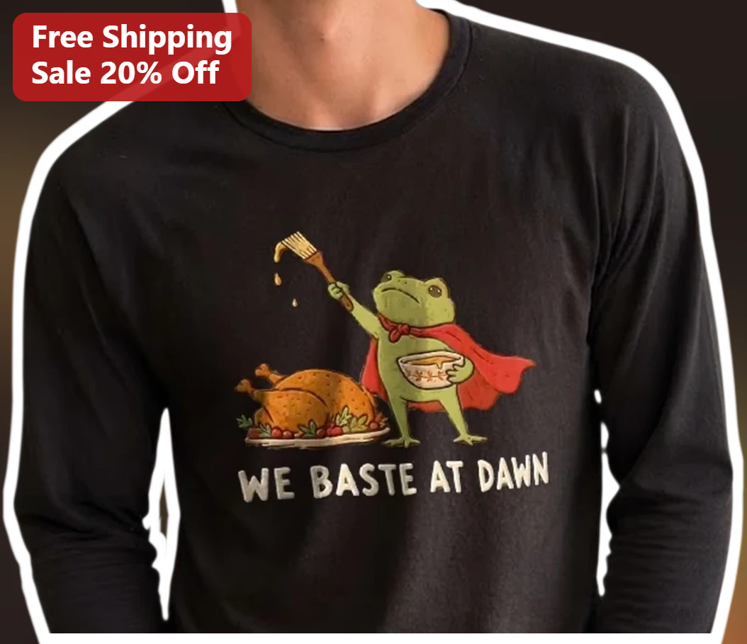 We Baste at Dawn Funny Thanksgiving Cooking Frog Long Sleeve — Los Angeles We Baste at Dawn Funny Thanksgiving Cooking Frog Long Sleeve Tee available at our Los Angeles warehouse